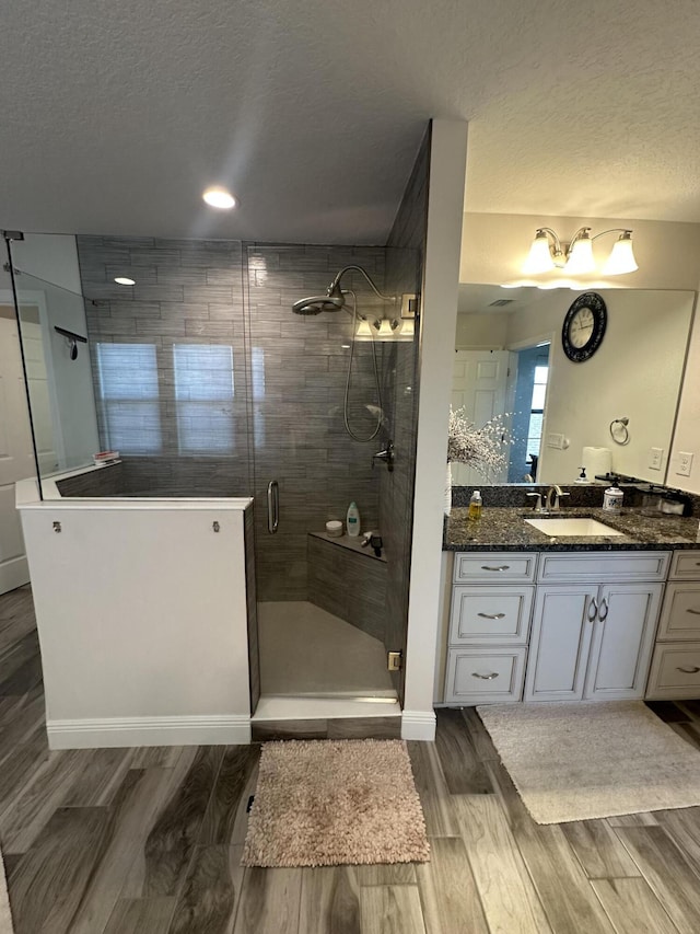 13106 Jeter Creek Dr, Riverview, FL 33579 - bathroom featuring a textured ceiling, wood finished floors, vanity, and a shower stall