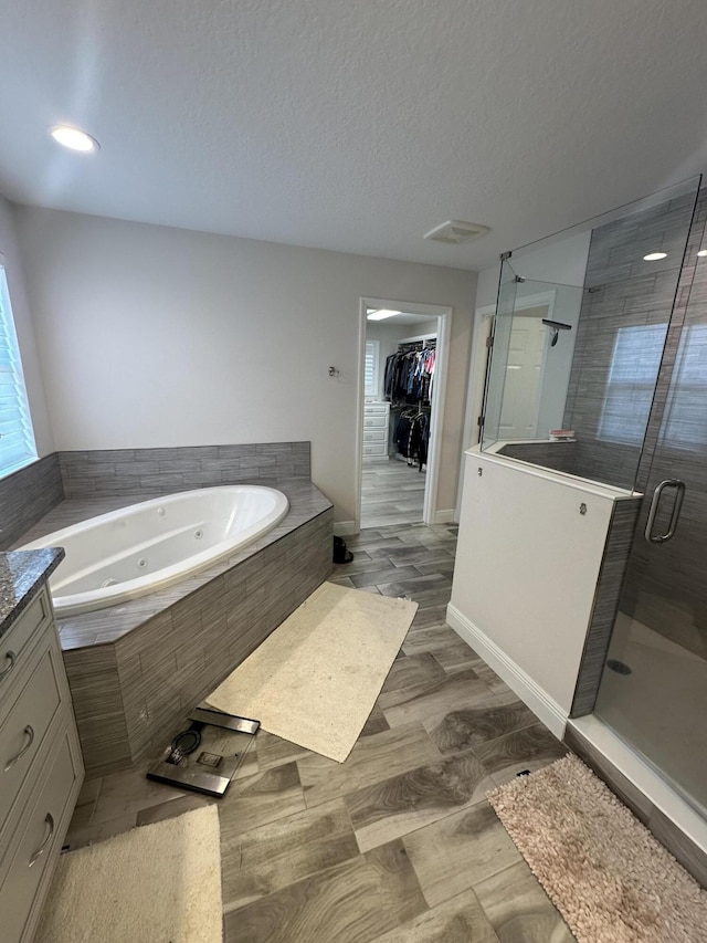 13106 Jeter Creek Dr, Riverview, FL 33579 - bathroom featuring a stall shower, a whirlpool tub, a textured ceiling, a walk in closet, and vanity