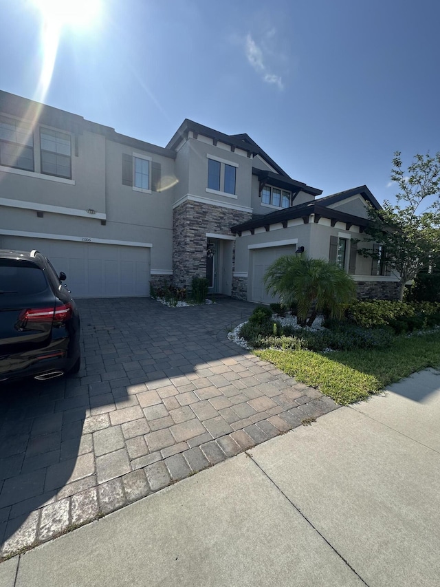13106 Jeter Creek Dr, Riverview, FL 33579 - view of front of home featuring stone siding, decorative driveway, stucco siding, and a garage