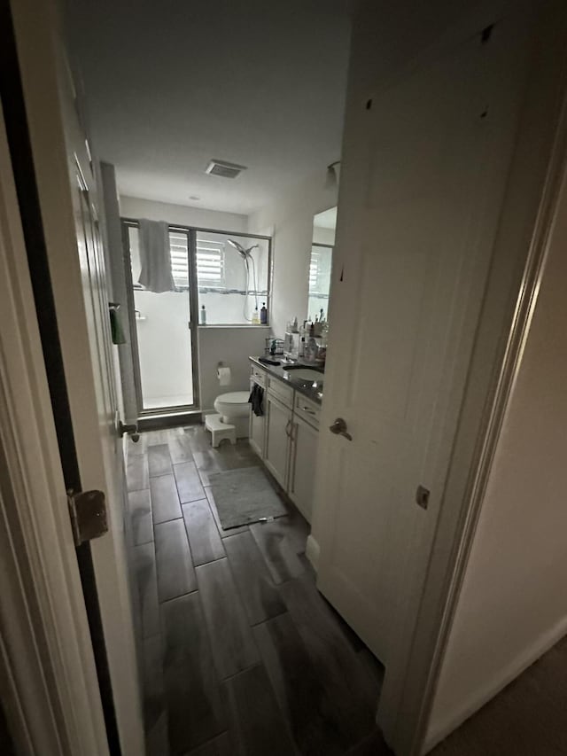 13106 Jeter Creek Dr, Riverview, FL 33579 - full bathroom featuring a shower with door, vanity, and wood finish floors