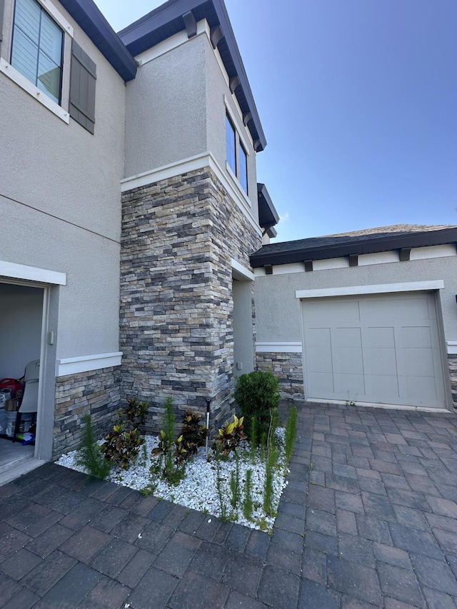 13106 Jeter Creek Dr, Riverview, FL 33579 - view of home's exterior with stone siding, stucco siding, an attached garage, and driveway