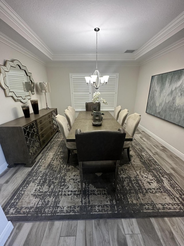 13106 Jeter Creek Dr, Riverview, FL 33579 - dining area with wood finished floors, a chandelier, ornamental molding, and a textured ceiling