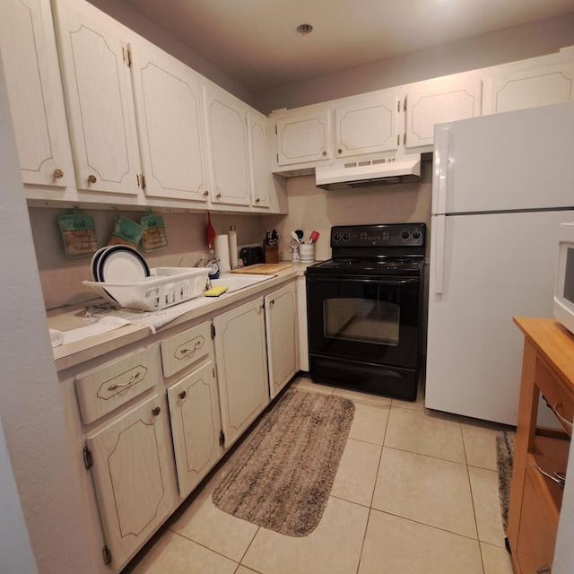70 Easthampton C, West Palm Beach, FL 33417 - kitchen featuring electric range, freestanding refrigerator, under cabinet range hood, and light countertops