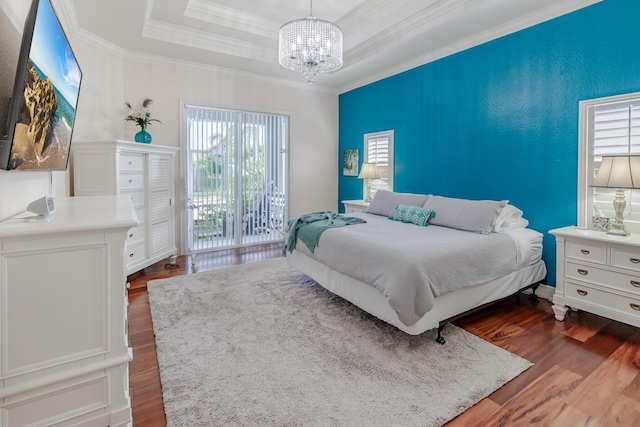1101 SW Kickaboo Rd, Port Saint Lucie, FL 34953 - bedroom featuring a chandelier, dark wood-style flooring, a raised ceiling, ornamental molding, and access to outside