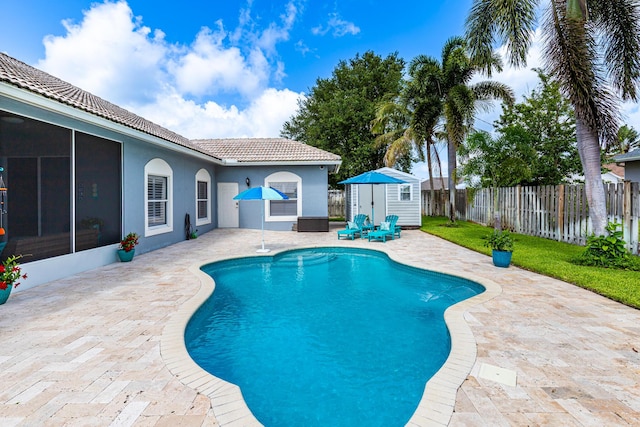 1101 SW Kickaboo Rd, Port Saint Lucie, FL 34953 - view of pool featuring a patio area, a storage shed, a fenced backyard, and a sunroom