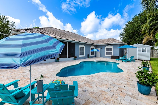 1101 SW Kickaboo Rd, Port Saint Lucie, FL 34953 - outdoor pool featuring a sunroom, a patio, and an outbuilding