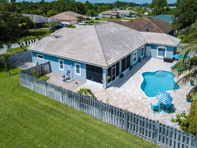 1101 SW Kickaboo Rd, Port Saint Lucie, FL 34953 - rear view of house with a patio, a sunroom, stucco siding, and a fenced backyard
