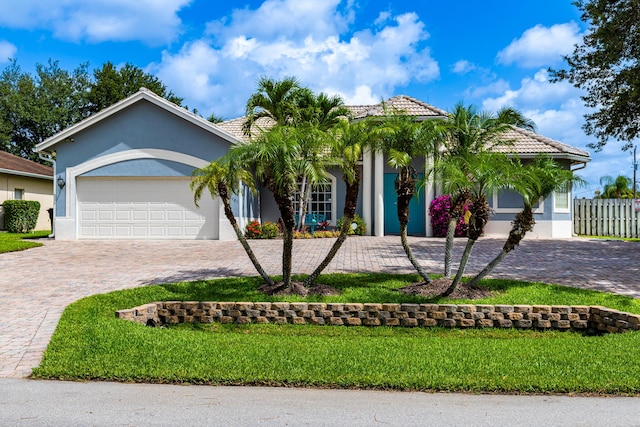 1101 SW Kickaboo Rd, Port Saint Lucie, FL 34953 - view of front of house with stucco siding, decorative driveway, a tile roof, and a garage