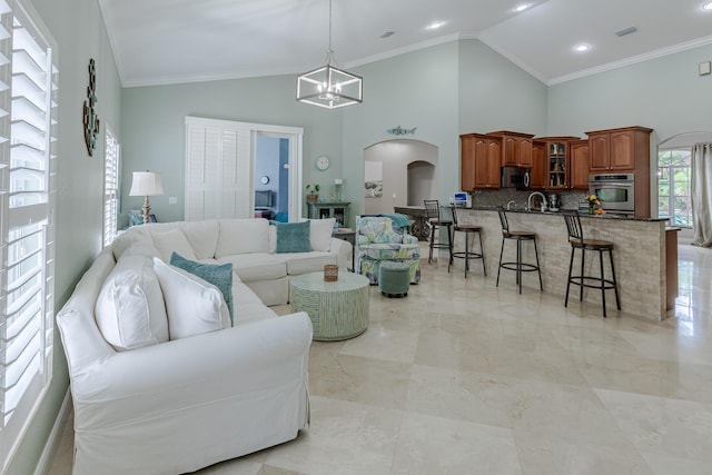 1101 SW Kickaboo Rd, Port Saint Lucie, FL 34953 - living room with arched walkways, a chandelier, crown molding, high vaulted ceiling, and light marble finish flooring