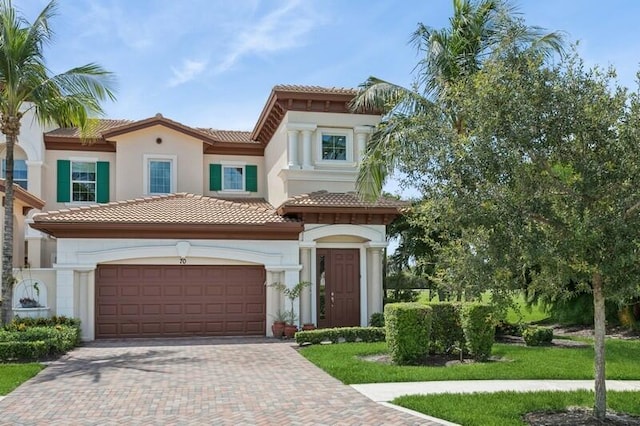242 Tresana Blvd Unit 70, Jupiter, FL 33478 - mediterranean / spanish-style home featuring a tile roof, decorative driveway, stucco siding, and an attached garage