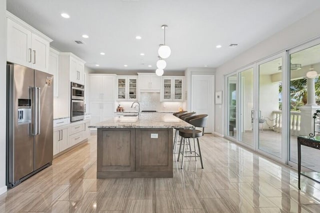 242 Tresana Blvd Unit 70, Jupiter, FL 33478 - kitchen with stainless steel appliances, recessed lighting, backsplash, white cabinets, and a kitchen island with sink