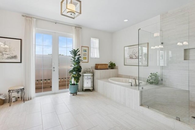 242 Tresana Blvd Unit 70, Jupiter, FL 33478 - bathroom featuring french doors, a bath, a stall shower, and tile patterned floors
