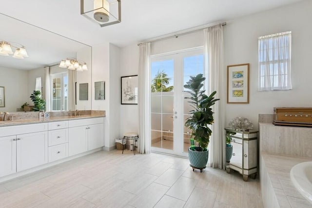 242 Tresana Blvd Unit 70, Jupiter, FL 33478 - full bathroom with double vanity, a garden tub, and french doors