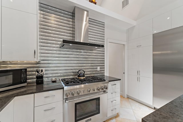 13709 Rivoli Dr, Palm Beach Gardens, FL 33410 - kitchen with stainless steel appliances, wall chimney range hood, decorative backsplash, white cabinets, and light tile patterned flooring