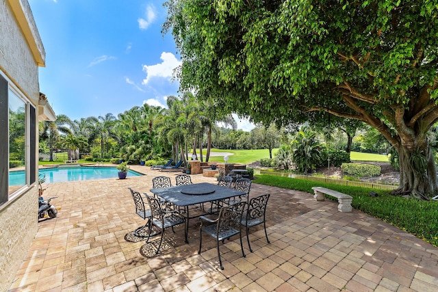 13709 Rivoli Dr, Palm Beach Gardens, FL 33410 - outdoor pool featuring a patio, outdoor dining area, and view of scattered trees