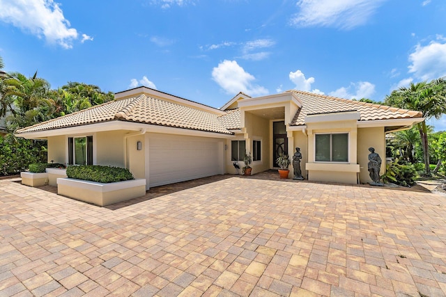 13709 Rivoli Dr, Palm Beach Gardens, FL 33410 - mediterranean / spanish home featuring a tiled roof, stucco siding, an attached garage, and driveway