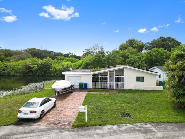 3560 SW 63rd Ave, Miramar, FL 33023 - mid-century home with a garage, a water view, stucco siding, and decorative driveway