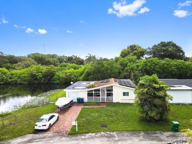 3560 SW 63rd Ave, Miramar, FL 33023 - mid-century inspired home with decorative driveway, solar panels, a water view, stucco siding, and a garage