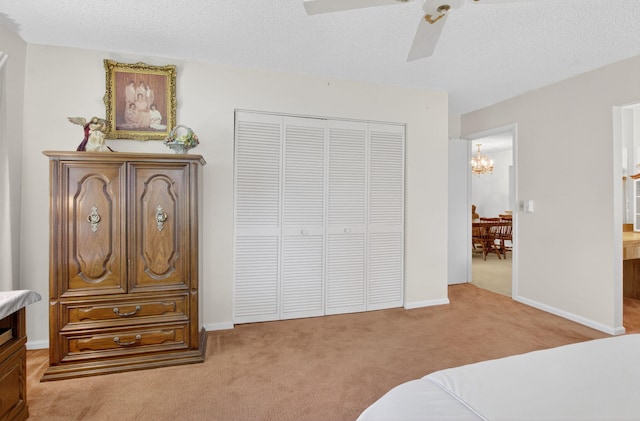 8811 SW 21st Ct Unit B, Boca Raton, FL 33433 - bedroom featuring light carpet, a chandelier, a closet, ceiling fan, and a textured ceiling