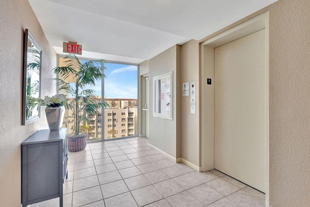 3540 S Ocean Blvd Ph 911, South Palm Beach, FL 33480 - hall with a textured wall, elevator, light tile patterned flooring, and floor to ceiling windows
