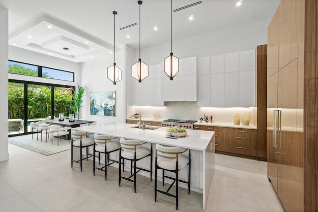 17 NW 15th St, Delray Beach, FL 33444 - kitchen featuring modern cabinets, a towering ceiling, a kitchen bar, light countertops, and recessed lighting