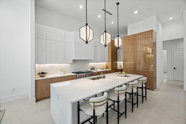 17 NW 15th St, Delray Beach, FL 33444 - kitchen featuring modern cabinets, high end stainless steel range, a large island with sink, brown cabinets, and a kitchen bar