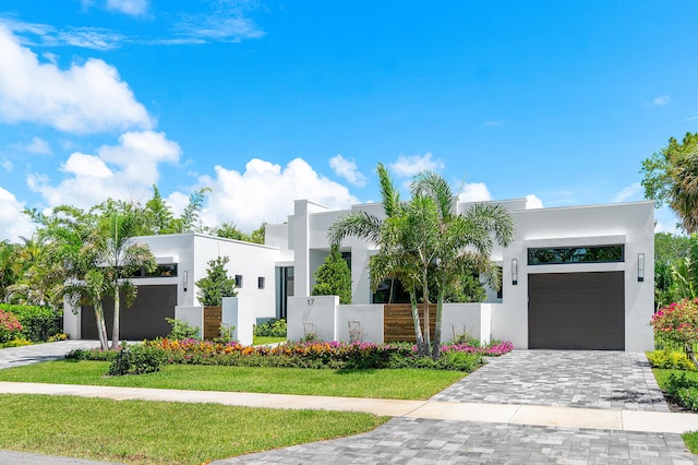 17 NW 15th St, Delray Beach, FL 33444 - modern home with stucco siding, decorative driveway, and a garage