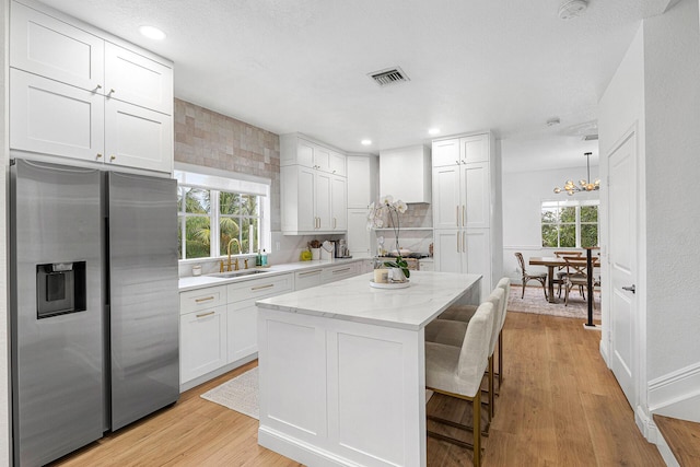 674 NW Library Commons Way, Boca Raton, FL 33432 - kitchen featuring stainless steel fridge with ice dispenser, healthy amount of natural light, and white cabinetry