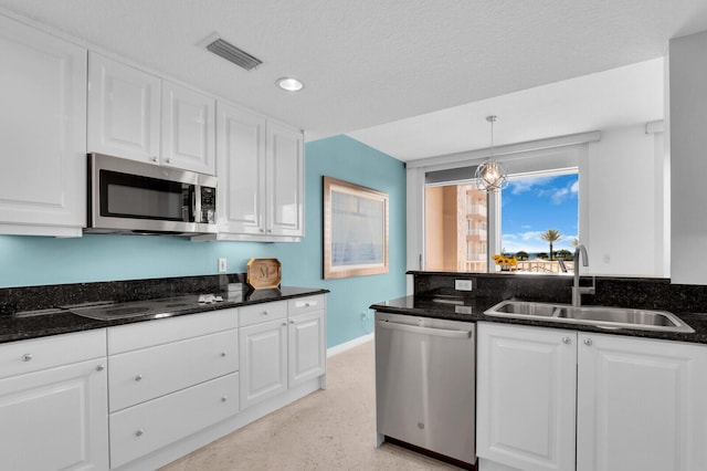 700 Ocean Royale Way Unit 202, Juno Beach, FL 33408 - kitchen with stainless steel appliances, white cabinetry, dark stone counters, and recessed lighting
