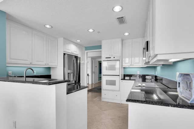 700 Ocean Royale Way Unit 202, Juno Beach, FL 33408 - kitchen featuring stainless steel appliances, recessed lighting, white cabinetry, dark stone countertops, and a peninsula