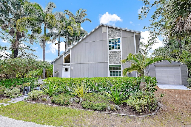 15629 95th Ave N, Jupiter, FL 33478 - view of home's exterior featuring a garage, stone siding, and driveway