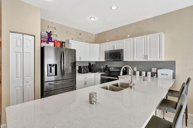 4463 Lake Tahoe Cir, West Palm Beach, FL 33409 - kitchen with appliances with stainless steel finishes, a peninsula, tasteful backsplash, and light stone countertops