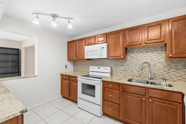 2203 Campanelli Blvd, Boynton Beach, FL 33426 - kitchen with white appliances, decorative backsplash, brown cabinets, and light stone countertops
