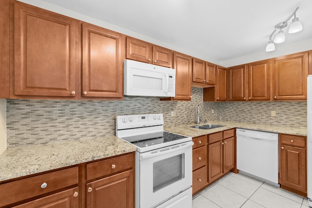 2203 Campanelli Blvd, Boynton Beach, FL 33426 - kitchen with white appliances, light tile patterned flooring, tasteful backsplash, brown cabinetry, and light stone countertops