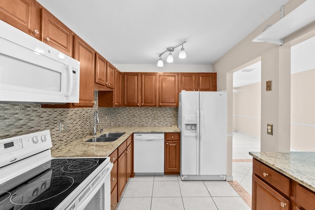 2203 Campanelli Blvd, Boynton Beach, FL 33426 - kitchen featuring white appliances, light tile patterned floors, backsplash, light stone counters, and brown cabinets
