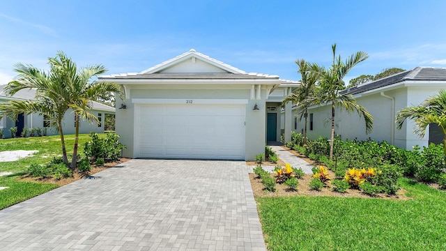 212 SE Via Sangro, Port Saint Lucie, FL 34952 - single story home featuring stucco siding, decorative driveway, a front yard, and an attached garage