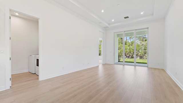 212 SE Via Sangro, Port Saint Lucie, FL 34952 - spare room with washing machine and dryer, light wood-style floors, a tray ceiling, and recessed lighting