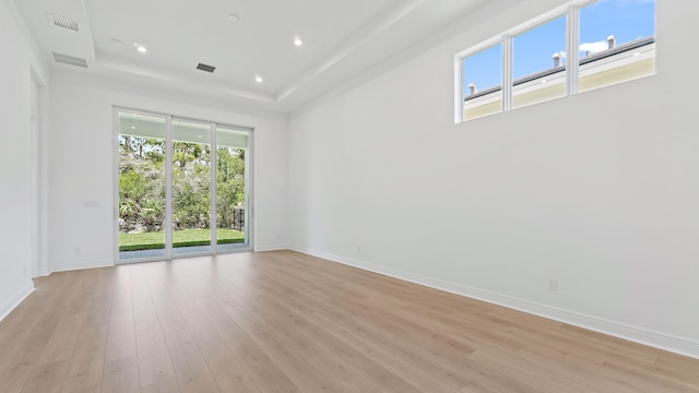 212 SE Via Sangro, Port Saint Lucie, FL 34952 - spare room featuring a raised ceiling, light wood-style flooring, and recessed lighting