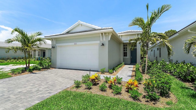 212 SE Via Sangro, Port Saint Lucie, FL 34952 - view of front of property featuring a garage, stucco siding, and decorative driveway