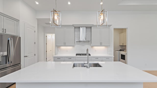 212 SE Via Sangro, Port Saint Lucie, FL 34952 - kitchen featuring stainless steel fridge, wall chimney range hood, separate washer and dryer, decorative backsplash, and light countertops