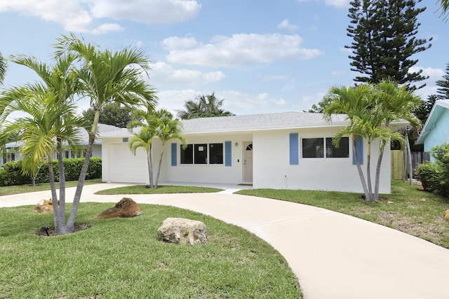 1893 Circle Dr, North Palm Beach, FL 33408 - ranch-style home with curved driveway, stucco siding, an attached garage, and a front lawn