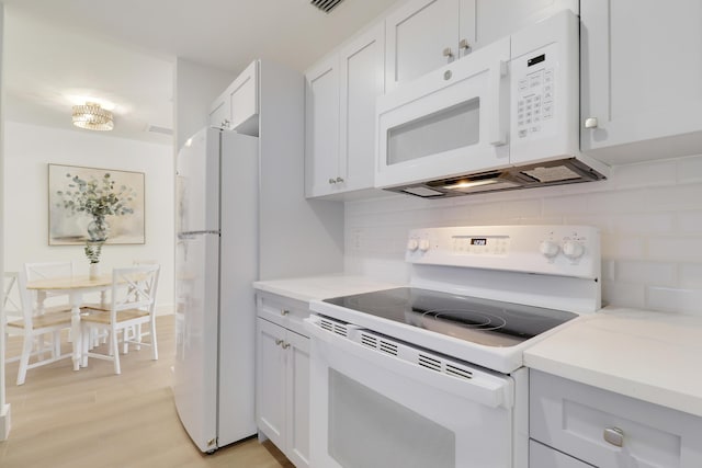 1893 Circle Dr, North Palm Beach, FL 33408 - kitchen with white appliances, backsplash, light countertops, and light wood finished floors
