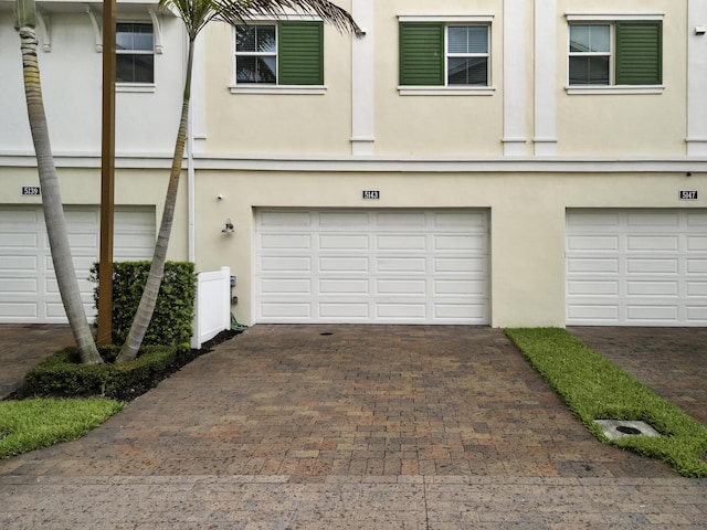 5143 Beckman Ter, Palm Beach Gardens, FL 33418 - townhome / multi-family property with a garage, stucco siding, and driveway