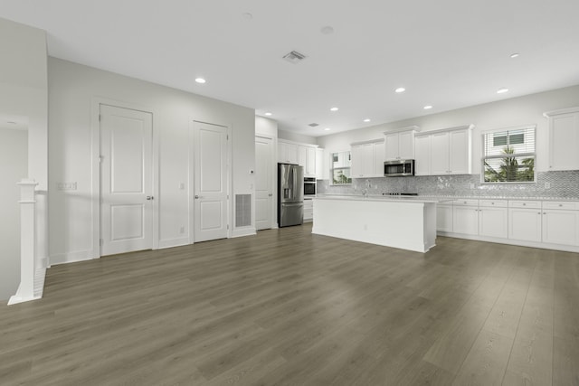 5143 Beckman Ter, Palm Beach Gardens, FL 33418 - kitchen featuring appliances with stainless steel finishes, wood finished floors, white cabinetry, tasteful backsplash, and recessed lighting