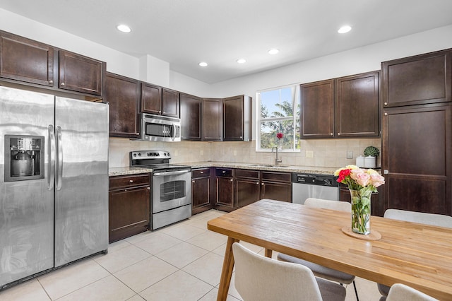 8274 Cascada Isles Dr, Cooper City, FL 33024 - kitchen featuring stainless steel appliances, dark brown cabinetry, decorative backsplash, light tile patterned flooring, and recessed lighting