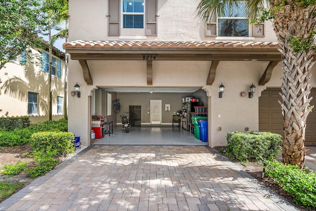 8274 Cascada Isles Dr, Cooper City, FL 33024 - rear view of property featuring a garage, stucco siding, decorative driveway, and a tile roof