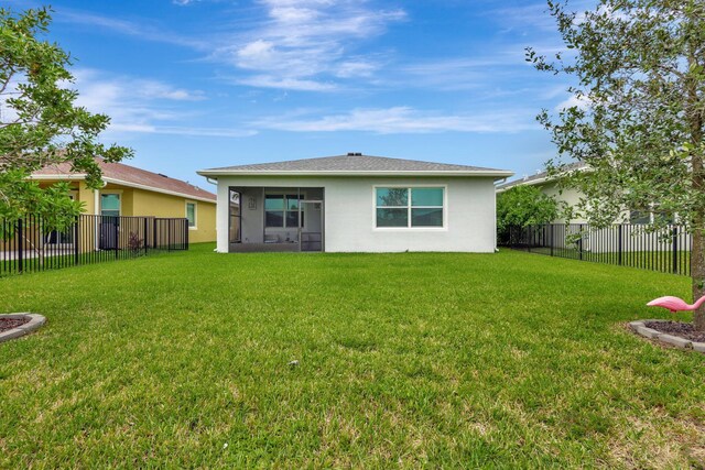 521 SE Plumeria Dr, Port Saint Lucie, FL 34984 - back of property with a fenced backyard, stucco siding, and a sunroom