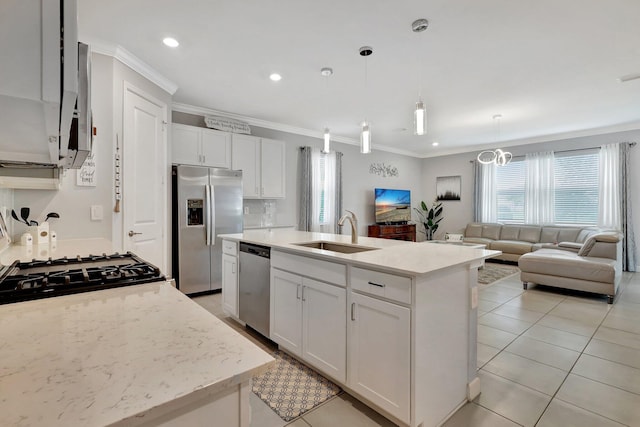 521 SE Plumeria Dr, Port Saint Lucie, FL 34984 - kitchen featuring stainless steel appliances, open floor plan, ornamental molding, white cabinets, and an island with sink
