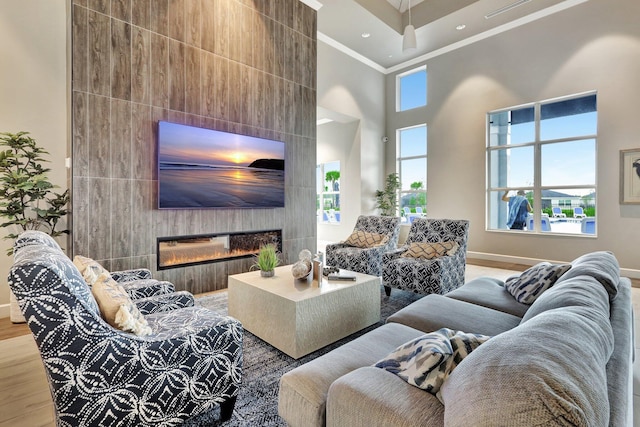 521 SE Plumeria Dr, Port Saint Lucie, FL 34984 - living area featuring crown molding, wood finished floors, a high ceiling, and a tiled fireplace