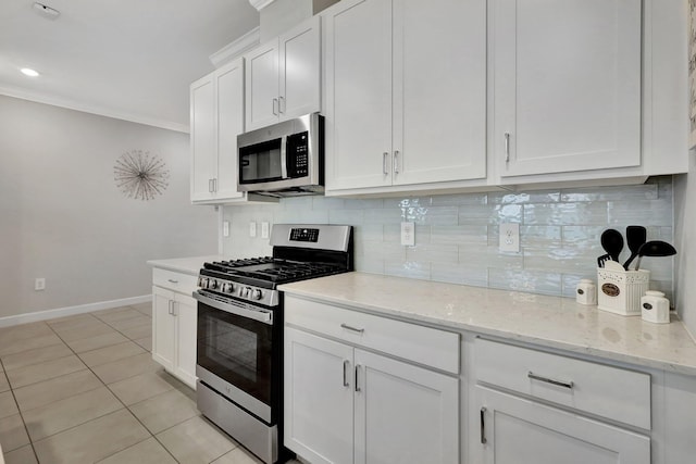 521 SE Plumeria Dr, Port Saint Lucie, FL 34984 - kitchen with appliances with stainless steel finishes, backsplash, crown molding, white cabinetry, and light stone counters